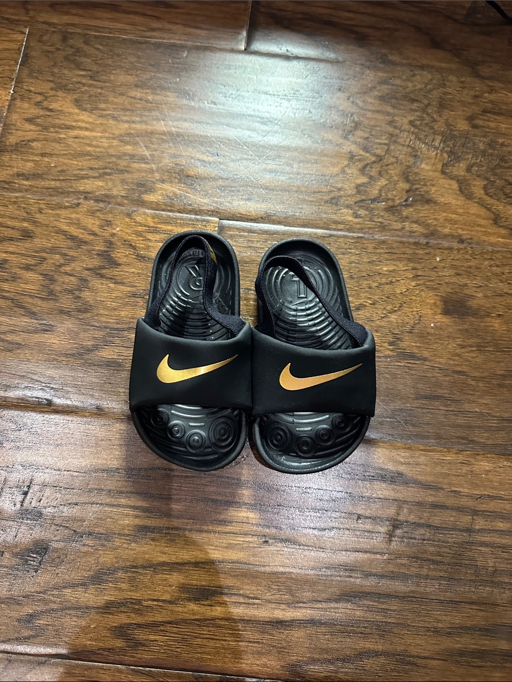 Nike Kids Black Slide Sandals with Gold Swoosh Accent